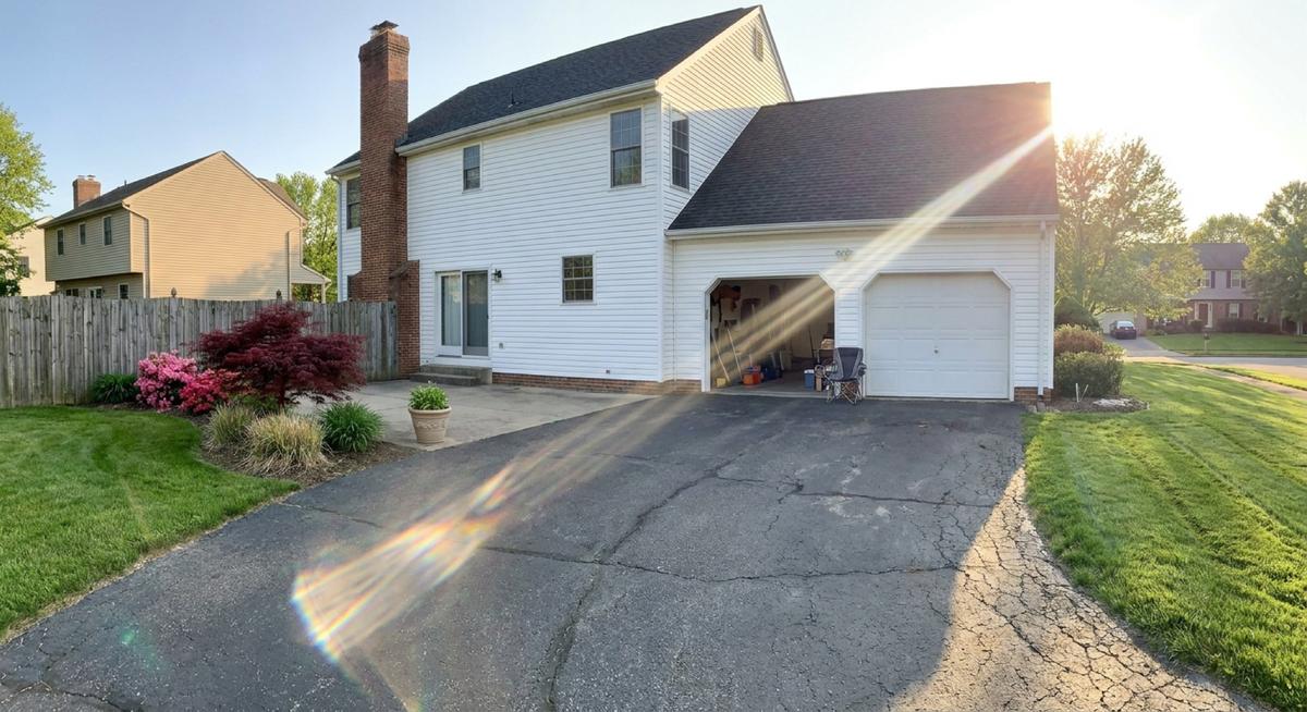 Sinking driveway repair candidate in Northern Virginia — a cracked, aging asphalt driveway showing signs of a failing base before repair